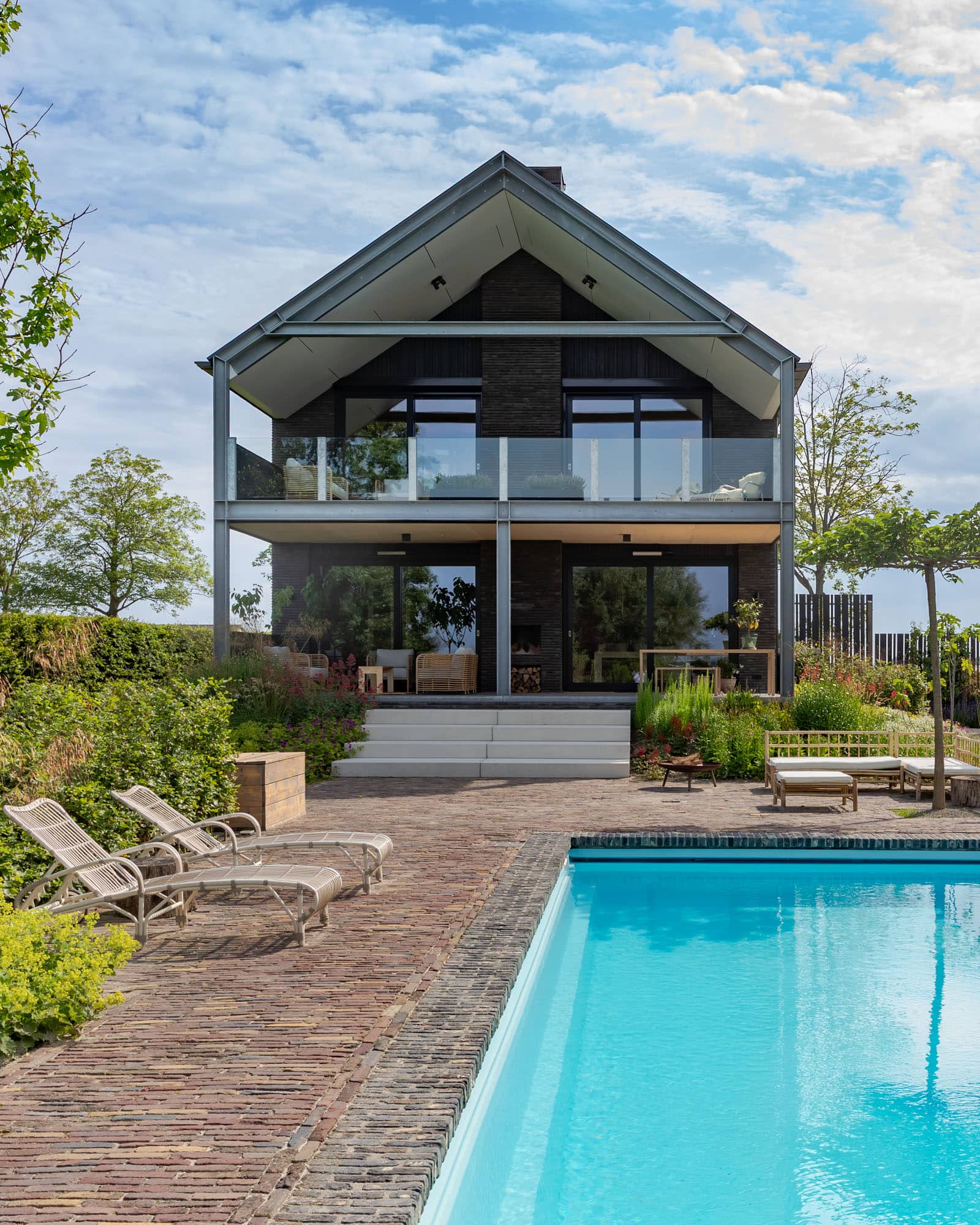 Modern barnstyle home with a pool on the foreground
