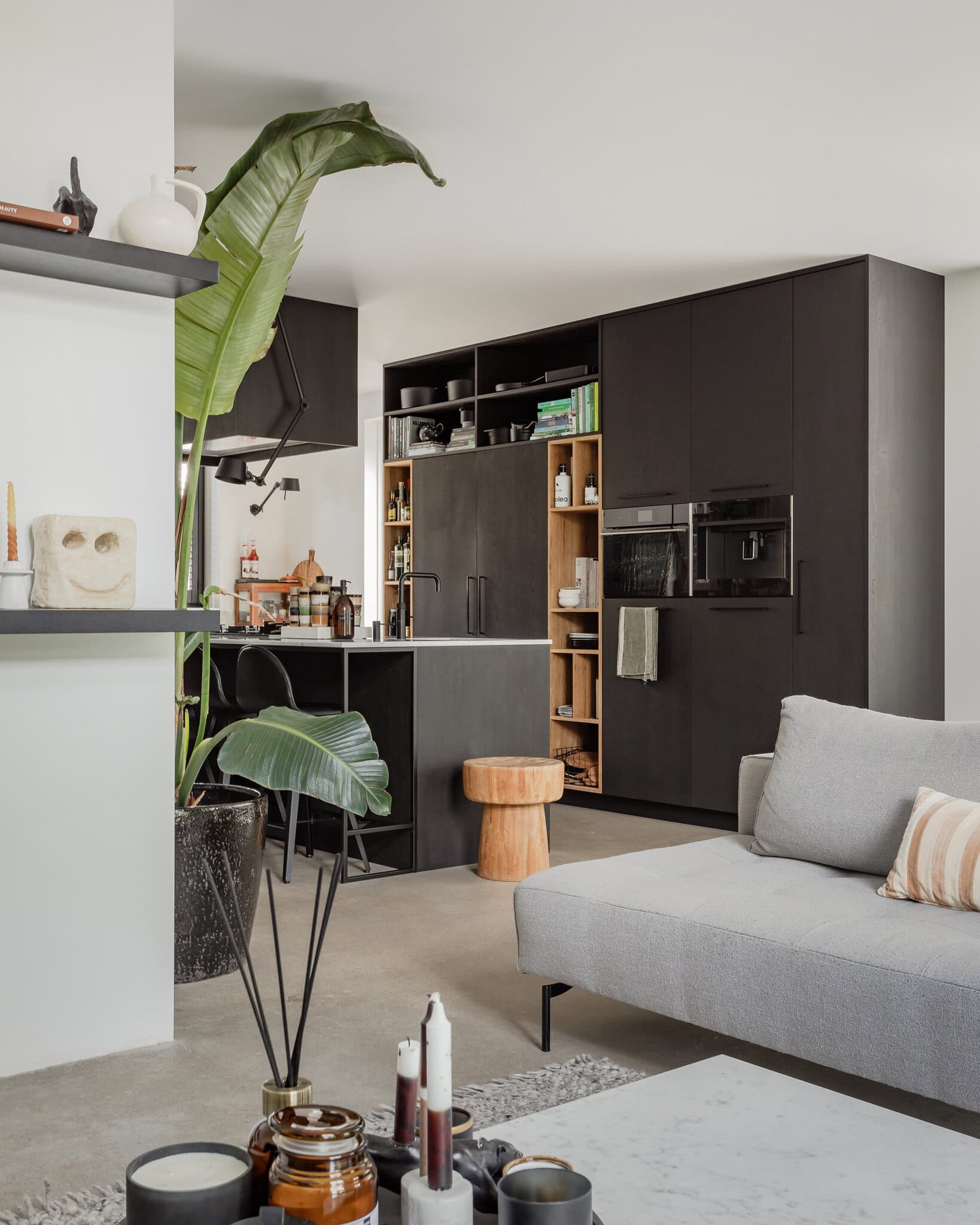 Real estate photography of a black kitchen photographed from the living room. A light, modern interior